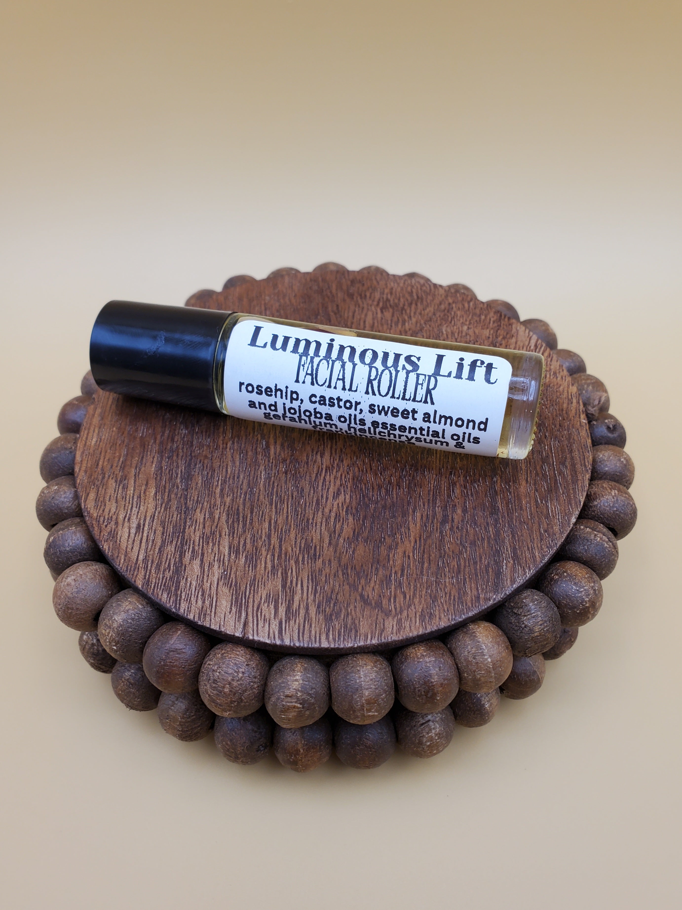 A clear glass bottle with a black cap, filled with yellow liquid